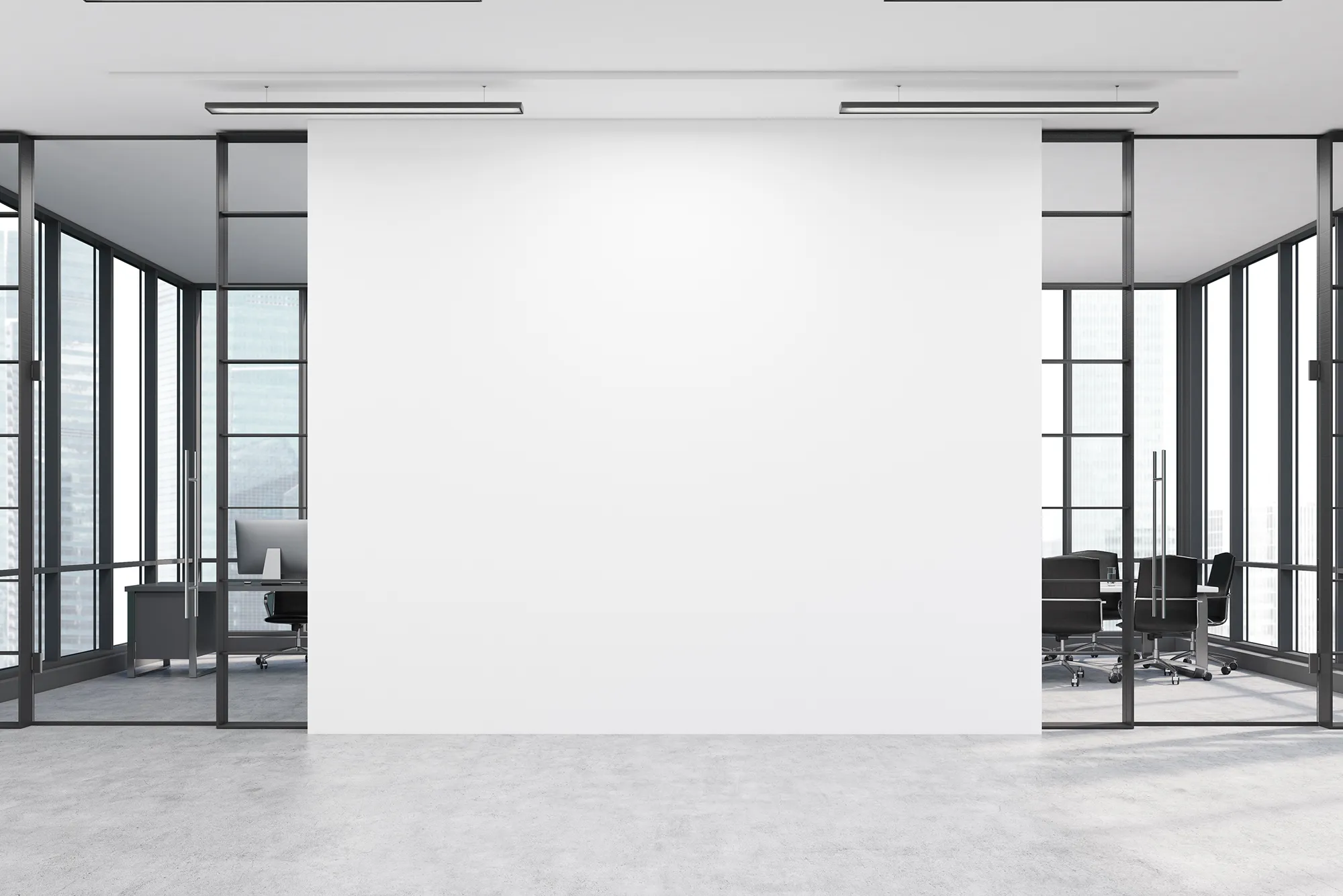 Modern gestalteter Büroraum mit großer weißer Wand und zeitgemäßer Einrichtung
